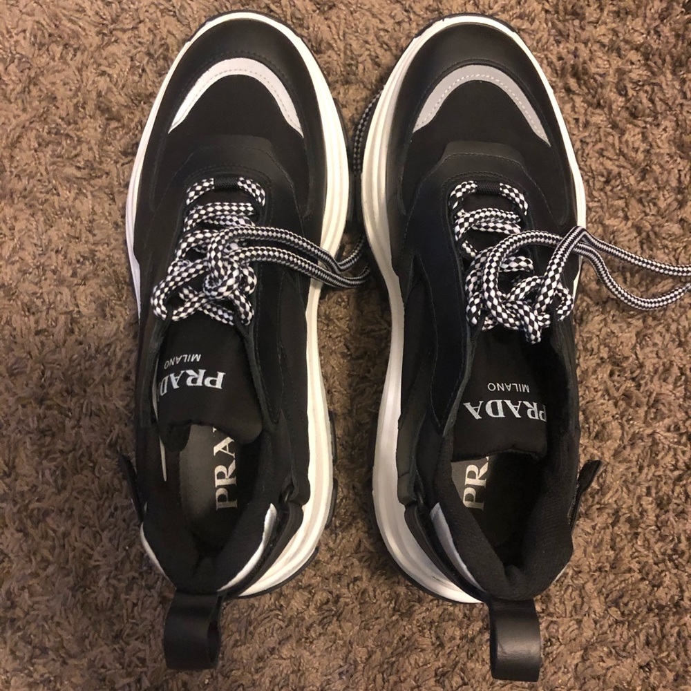 Prada Pegasus lace up sneakers in leather & nylon.